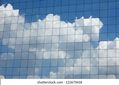 Clouds reflected in windows of modern office building