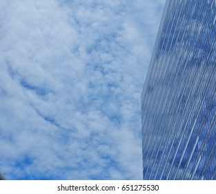 Clouds reflected in windows of modern office building.