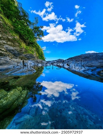 Clouds reflecting in a tidal pool at Nosara beach in Nosara, Costa Rica