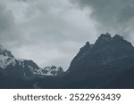 Clouds and rocky cliffs in Italy, Dolomiti. View in alps mountains. Snowy mountains in low clouds in rainy weather.