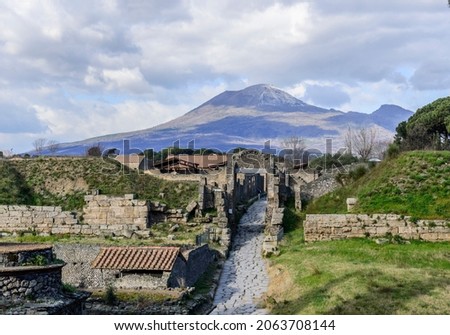Clouds in the sky above the ancient roman ruines and the city gate Porta Nocera and mount Vesuvius in town of Pompeii, Italy.  