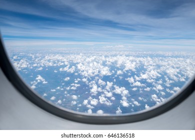 Clouds and sky as seen through window of an aircraft