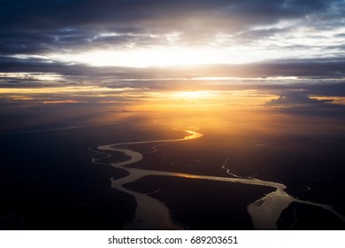 Clouds And Sky As Seen Through Window Of An Aircraft. Flying Over The Evening Timelapse Clouds With The Late Sun. Flight Through Moving Cloudscape With Beautiful Sun Rays.