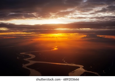 Clouds And Sky As Seen Through Window Of An Aircraft. Flying Over The Evening Timelapse Clouds With The Late Sun. Flight Through Moving Cloudscape With Beautiful Sun Rays.