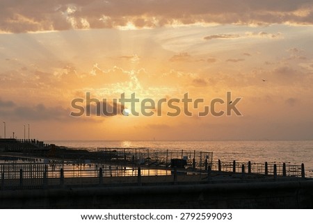 Clouds, sky and sunset with pier at ocean for natural background or scenic wallpaper. Evening, horizon and space with seaside boardwalk or jetty outdoor in nature for dusk and twilight scenery