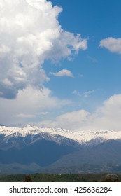 clouds, snow-capped mountains in the background of white clouds and blue sky