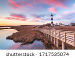Clouds stream like pink ribbons in the sky over the marsh and lighthouse on Bodie Island on the Outer Banks of North Carolina.