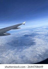 Clouds, with their fluid forms, teach us the nature of reality’s transience, yet the airplane insists on carving a rigid path toward its destination.
