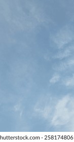 The clouds are thin and delicate, adding a touch of texture to the otherwise uniform blue background. The photo is taken from a low angle, looking straight up at the sky.