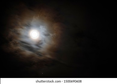 The clouds through the moon. Moon light through the clouds on dark night sky show beautiful texture on nature landscape. - Image