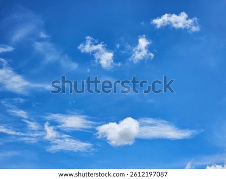 The clouds vary in shape and size, some appearing as small, wispy streaks while others are more substantial and puffy.