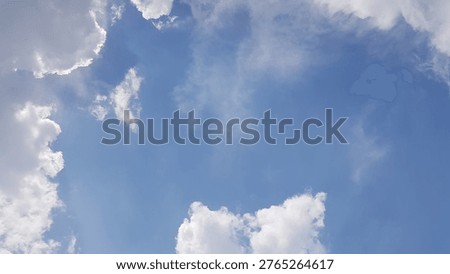 A cloudscape featuring white, fluffy clouds set against a clear blue sky.