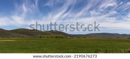 Cloudscape over the green fields in a city during sunny day. Evanston, Wyoming, United States of America. Nature Background.