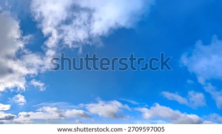 Cloudscape white clouds panorama. A wide panoramic of low-flying cumulus cloud of varying sizes. Voluminous space-occupying lesions of steam against a blue background. The sky in serene motion.
