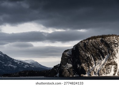 Cloudy bay with cliffs and distant mountains - Norris Point, Newfoundland, Canada.