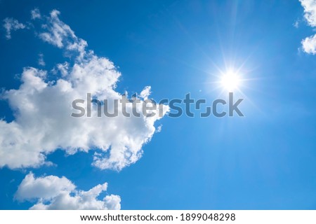 Cloudy blue sky on a sunny day. The sun and the sun's rays against the blue sky