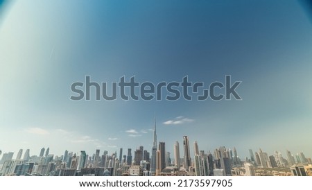 Cloudy blue sky over panoramic skyline of Dubai with business bay and downtown district timelapse. Aerial view of many modern skyscrapers. United Arab Emirates.