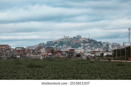 A cloudy day in a suburb of Antananarivo, Madagascar with colorful houses and greenery in the foreground - Powered by Shutterstock