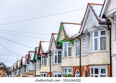 Cloudy Day Winter View of Row of Typical English Terraced Houses under snow in Northampton