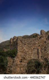 A cloudy evening in the mountains. The completion of the archaeological expedition. Ruins of the ancient city in the mountains in the evening. Foggy view of old stone buildings and streets. Twilight.