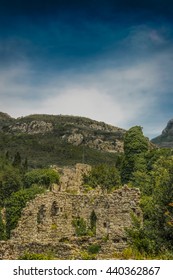 A cloudy evening in the mountains. The completion of the archaeological expedition. Ruins of the ancient city in the mountains in the evening. Foggy view of old stone buildings and streets. Twilight.