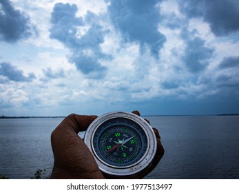 Cloudy lake view point with magnetic compass emphasizing  travel 