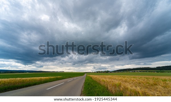 Cloudy landscape of the sky before the storm above\
country roads and fields