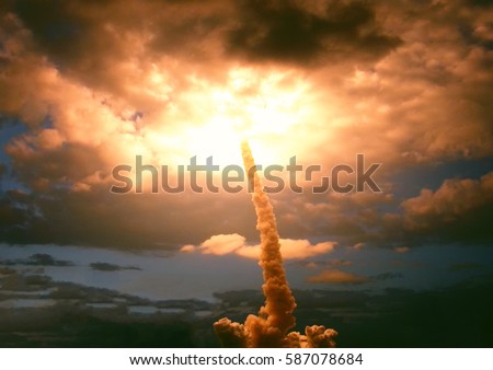 Cloudy launch of rocket into dramatic purple skies. 