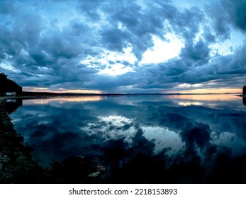 Cloudy Morning Sky Over A Quiet, Calm Lake