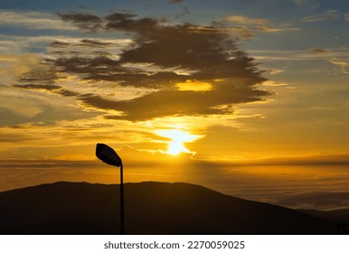 cloudy mountains and a street lamp at sunrise - Powered by Shutterstock