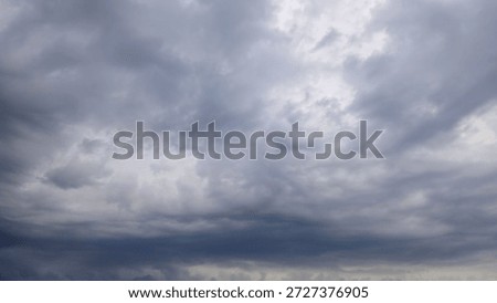 The cloudy sky was covered with thick dark gray cumulonimbus clouds, indicating rainy weather.