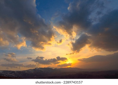 Cloudy sky. Dramatic sunset landscape with puffy clouds lit by orange setting sun and blue sky. - Shutterstock ID 2289743157