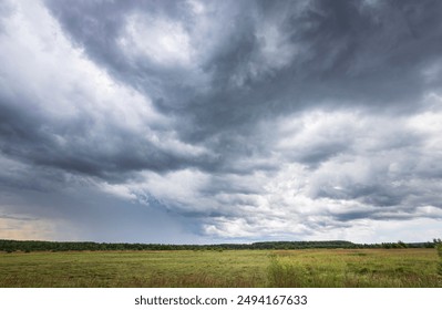 A cloudy sky with a few clouds in the distance. The sky is mostly gray and the clouds are scattered throughout - Powered by Shutterstock