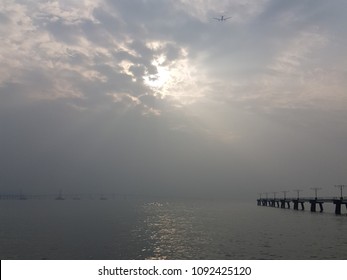 Cloudy sky with flying plane on the pier