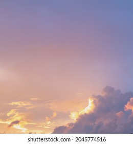 cloudy sky with golden and pink tint of clouds at sunset.