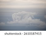A cloudy sky with a large cloud in the middle. The sky is mostly gray with a few white clouds