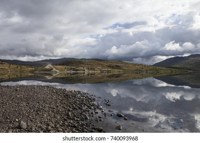 cloudy sky and mountains reflecting on a norwegian lake in Norway