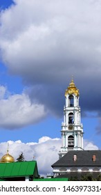 Cloudy sky over monastery roofs and bellfry