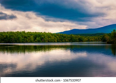 A Cloudy Sky Reflects In The Calm Waters Of An Appalachian Lake In The Mountains