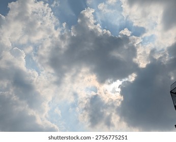 A cloudy sky with sunlight filtering through the gaps, creating sunbeams. 