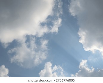 A cloudy sky with sunlight filtering through the gaps, creating sunbeams. 
