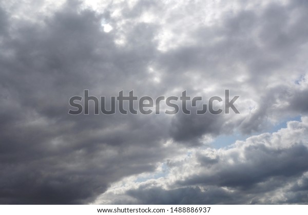 暖かい夏の日に曇った空 晴れた日の青い空に大きなふわふわした雲 白い雲の上の薄い部分に太陽の光が照ります 雲の一部は濃いグレー色をしている の写真素材 今すぐ編集