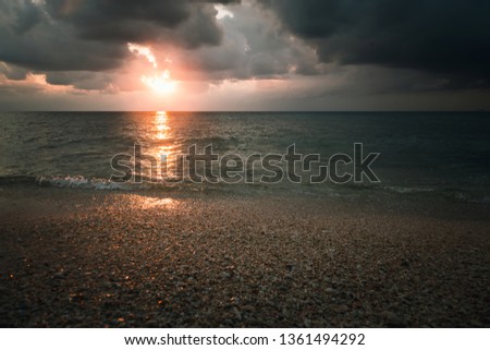 cloudy sunset over the sea in a rocky beach with stones and red dusk. epic sky. Andaman and Nicobar Islands. Neil to Havelock Goa Kerala India
