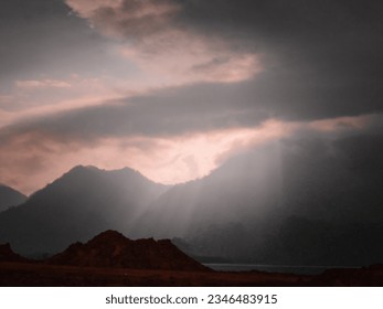 cloudy sunset with rays of light over the mountain 