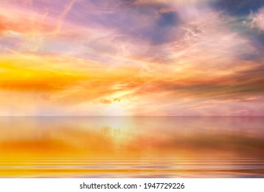 cloudy sunset at sea yellow pink blue pastel colors sun beam reflection on light blue sea water nature lanscape