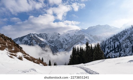 Cloudy weather. Mountain snow peaks in the clouds. Misty Mountains - Powered by Shutterstock