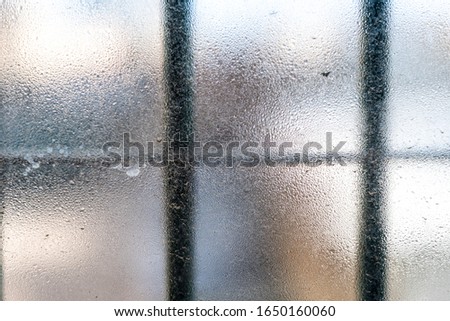Cloudy window with bars in prison