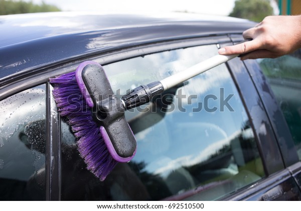 Clouse up washing the car with brush outdoor .\
Car cleaning concept\
related