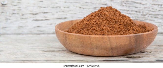 Clove Powder In Wooden Bowl Over Wooden Background