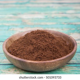 Clove Powder In Wooden Bowl Over Wooden Background